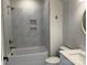 This bathroom features marble-look tile, a white tub and toilet, and gold finishes at 4374 Morning Mist Dr # 25, Sherrills Ford, NC 28673