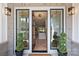 Inviting entryway with a glass front door, sidelights, transom window, and green topiaries at 571 Lyttleton Dr, Charlotte, NC 28211