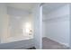 Clean bathroom featuring a tub with shower and an open doorway to a walk-in closet with wire shelving at 310 Foster Ln, Albemarle, NC 28001