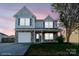 Charming two-story home showcasing stone accents, blue shutters, and a well-manicured lawn at 310 Foster Ln, Albemarle, NC 28001