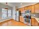 Well-lit kitchen with stainless steel appliances, wood cabinets, granite countertops, and hardwood floors at 4006 Trinity Ct, Indian Land, SC 29707