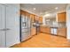 Modern kitchen featuring stainless steel appliances, wood cabinets, granite counters, and hardwood floors at 4006 Trinity Ct, Indian Land, SC 29707