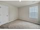 Bright bedroom with carpeted floor, neutral walls, and a window at 117 Dorian Pl, Troutman, NC 28166