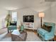 Living area with teal accent chairs and a geometric coffee table, showcasing the open floor plan at 117 Dorian Pl, Troutman, NC 28166