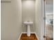 Small powder room with pedestal sink and wood flooring at 117 Dorian Pl, Troutman, NC 28166