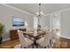 Virtually staged dining room with hardwood floors, chandelier, and view into kitchen at 1360 Barnett Woods, Fort Mill, SC 29708