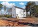 Side and backyard of two-story home with new patio and unfinished lot at 150 Roxie Ln, Belmont, NC 28012