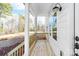 Covered porch with wood decking, white columns, and classic black outdoor lighting at 150 Roxie Ln, Belmont, NC 28012