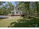 Exterior of a white two-story home with a wooden deck nestled in a wooded area at 1062 Full Count Ln, Lancaster, SC 29720