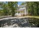 Charming white two-story home with a welcoming front porch and a spacious gravel driveway nestled in a wooded lot at 1062 Full Count Ln, Lancaster, SC 29720