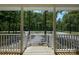 A view from the front porch with white railing shows the gravel driveway and wooded view at 1062 Full Count Ln, Lancaster, SC 29720