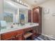 Well-lit bathroom with double sinks, dark wood cabinets, and ample counter space at 1136 Preakness Nw Ct, Concord, NC 28027