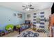 Cozy bedroom features a ceiling fan, natural light, and playful decor at 1136 Preakness Nw Ct, Concord, NC 28027