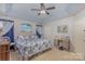 Inviting bedroom with a floral-patterned bedspread, tray ceiling, and calming blue accents at 1136 Preakness Nw Ct, Concord, NC 28027