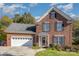 Charming two-story brick home with attached garage, manicured landscaping, and a welcoming front entrance adorned with a seasonal wreath at 1136 Preakness Nw Ct, Concord, NC 28027