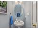 Stylish powder room featuring a pedestal sink, oval mirror, and soft lighting at 1136 Preakness Nw Ct, Concord, NC 28027