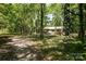 A cozy, wooded homesite surrounded by lush trees and a gravel driveway at 1216 Stallion Ln, Lancaster, SC 29720