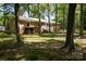 Brick home with an outdoor covered patio, nestled among mature trees at 1216 Stallion Ln, Lancaster, SC 29720
