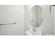 Simple powder room with a pedestal sink, an oval mirror and brushed nickel hardware at 127 High Ridge Rd, Mooresville, NC 28117