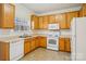 Kitchen with oak cabinets, white appliances, and tile floor at 127 High Ridge Rd, Mooresville, NC 28117