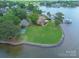 Beautiful lakefront home with a well-manicured lawn, boat dock, and mature trees at 18210 Pompano Pl, Cornelius, NC 28031