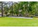 Outdoor basketball court surrounded by mature trees and lush green lawn at 18210 Pompano Pl, Cornelius, NC 28031
