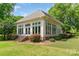 Close up of the exterior of the outbuilding with a brick staircase, large windows, and lush landscaping at 18210 Pompano Pl, Cornelius, NC 28031