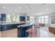 Spacious kitchen with blue cabinets and tile countertops, accented by a breakfast bar and chandelier at 18210 Pompano Pl, Cornelius, NC 28031