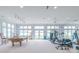 Large recreation room featuring a pool table, gym equipment, and natural light with water views at 18210 Pompano Pl, Cornelius, NC 28031