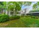 Backyard featuring manicured lawn, mature trees, a beautiful bench, and the rear of the house at 1919 Kensal Ct, Charlotte, NC 28211