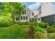 Backyard featuring manicured lawn, mature trees, a beautiful bench, and the rear of the house at 1919 Kensal Ct, Charlotte, NC 28211