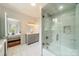 Bathroom featuring marble tiling, bathtub with glass enclosure, and gray vanity, providing a spa-like experience at 1919 Kensal Ct, Charlotte, NC 28211