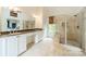 Bright bathroom with double sink vanity, stone counters, and glass shower at 1919 Kensal Ct, Charlotte, NC 28211