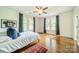 Bright bedroom with hardwood floors, three windows, ceiling fan, and Carolina Panthers jersey art at 1919 Kensal Ct, Charlotte, NC 28211