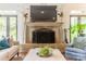 A living room fireplace with a large mantle and hearth, surrounded by lush greenery and soft light at 1919 Kensal Ct, Charlotte, NC 28211