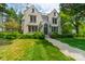 Stunning stone home with manicured lawn, mature trees, and a welcoming walkway leading to the front door at 1919 Kensal Ct, Charlotte, NC 28211