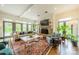 Airy living room with a fireplace, large windows, hardwood floors, and access to the backyard at 1919 Kensal Ct, Charlotte, NC 28211