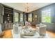 Cozy sitting room with built-in shelves, unique chandelier, and three comfortable chairs at 1919 Kensal Ct, Charlotte, NC 28211