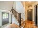 Elegant staircase featuring hardwood steps, dark wood banister, and a well-lit entryway at 1919 Kensal Ct, Charlotte, NC 28211