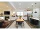 Open concept dining area with wood table and chairs, adjacent to the kitchen and fireplace at 216 Portrait Way, Indian Trail, NC 28079