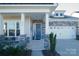 Charming front porch with stone pillars and a bright blue door at 216 Portrait Way, Indian Trail, NC 28079