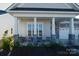 Inviting front porch with white columns and comfortable seating at 216 Portrait Way, Indian Trail, NC 28079