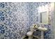 Powder room with pedestal sink and blue floral wallpaper at 216 Portrait Way, Indian Trail, NC 28079