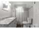 Bright bathroom featuring a granite countertop sink and a shower-tub with decorative curtain at 305 N White St, Lancaster, SC 29720