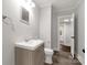 Well-lit bathroom features modern vanity, faucet, mirror, with gray walls and hardwood floor at 305 N White St, Lancaster, SC 29720