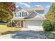 Inviting two-story house with a brick and siding facade, complemented by a green lawn and blossoming autumn foliage at 4707 Hannah Dr, Rock Hill, SC 29732