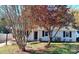 Charming one-story home with white siding, navy blue shutters, and mature trees at 5105 Chelsey Ln, Monroe, NC 28110