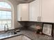 Bright kitchen corner with granite countertops, white cabinets, and an arched window at 5105 Chelsey Ln, Monroe, NC 28110