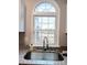 Kitchen sink and faucet with granite countertops and an arched window overlooking yard at 5105 Chelsey Ln, Monroe, NC 28110