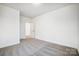 Bright bedroom with grey carpet and an open door to another room at 5226 Verona Rd # 81, Charlotte, NC 28213